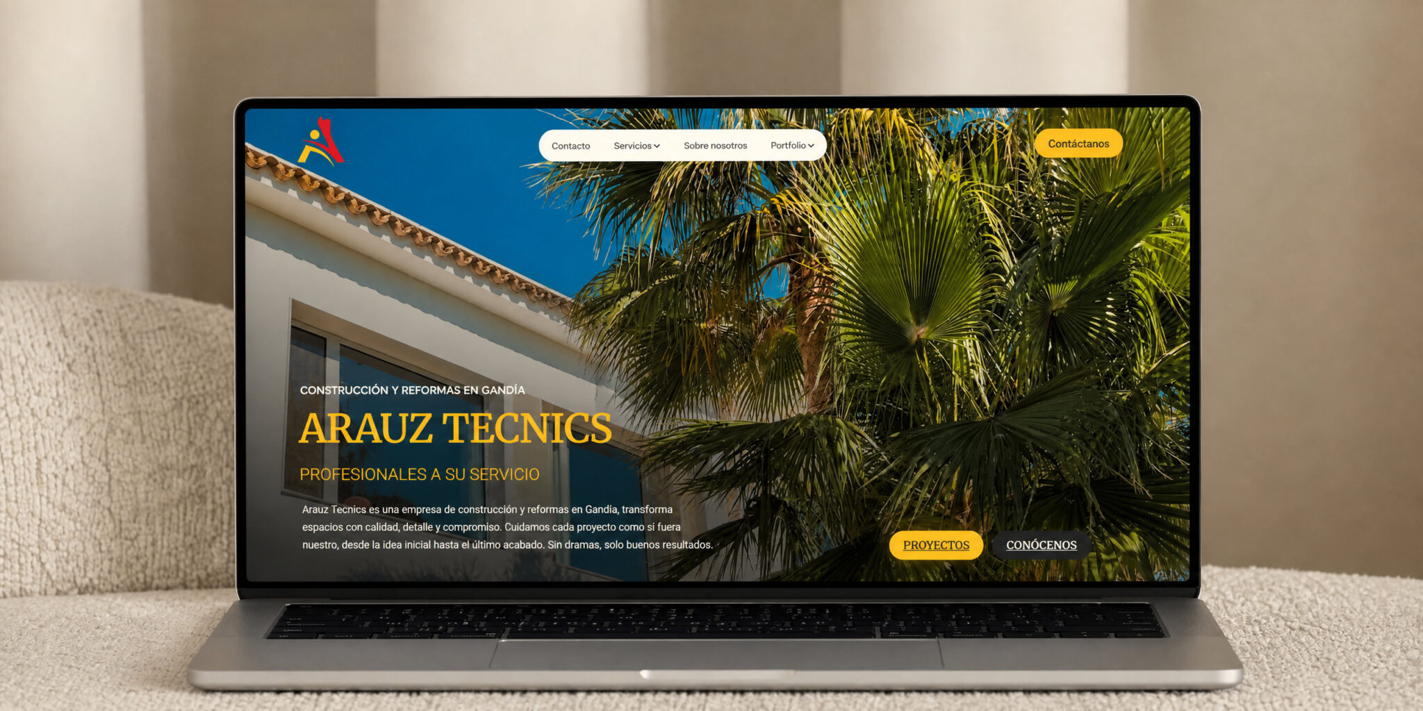 Web de Arauz Tecnics en un portátil sobre un sofá